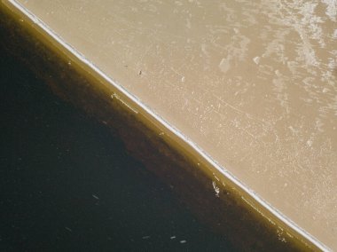 Nehrin kumlu kıyısında hafif kar. Hava aracı görünümü.