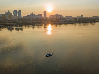 Gün batımında suda bir balıkçı teknesi. Hava aracı görünümü.