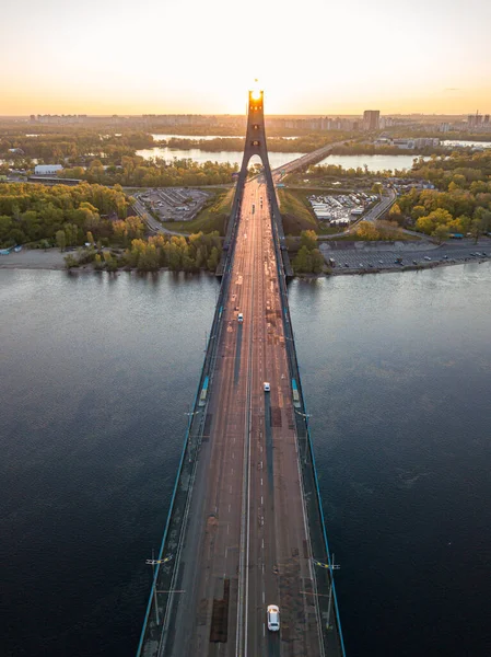 Kiev 'in kuzey köprüsü. Köprü boyunca yükselen güneş ışınları. Güneş pilonun içinden doğuyor. Hava aracı görünümü.