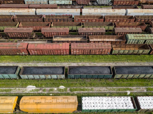 Freight trains on railway tracks. Aerial drone top view. Sunny spring day.