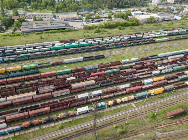 Freight trains on railway tracks. Aerial drone top view. Sunny spring day.