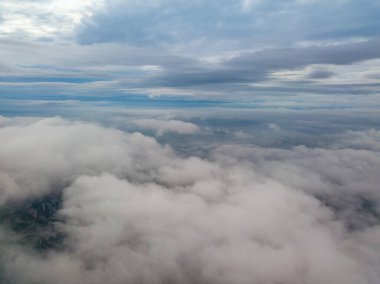 Bulutların üzerinde havadan yüksek uçuş. Yükselen güneşin ışınları bulutları delip geçer..