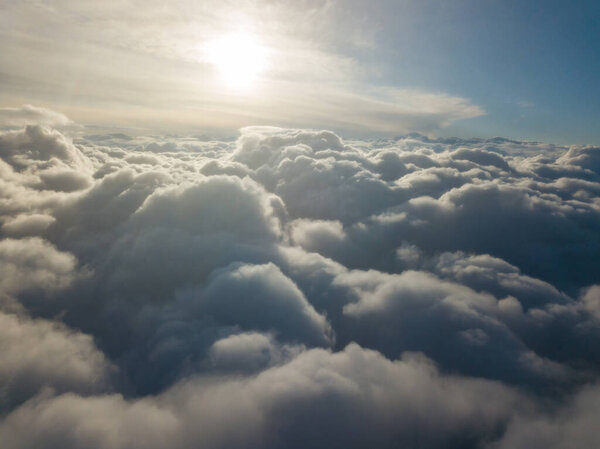 Высокий воздушный полет над облаками на восходе солнца.