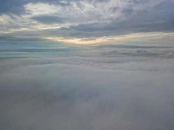 雲の上の空中高飛行 雲の中から昇る太陽の光 — ストック写真