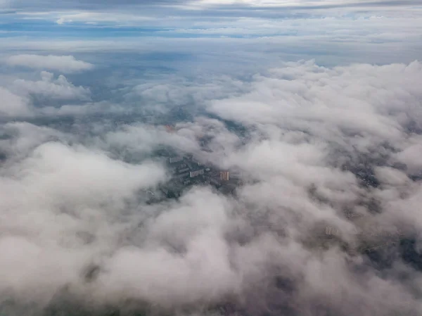 City under the clouds at dawn. Aerial high drone view.