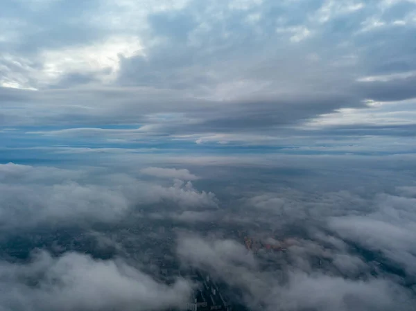 City under the clouds at dawn. Aerial high drone view.