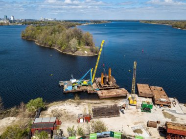 Nehir kıyısında bir yaya köprüsü inşaatı. Hava aracı görünümü.