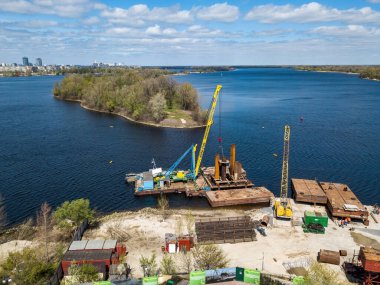 Nehir kıyısında bir yaya köprüsü inşaatı. Hava aracı görünümü.