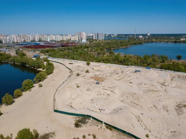 Şehrin varoşlarındaki gölün kumlu kıyısında. Hava aracı görünümü.