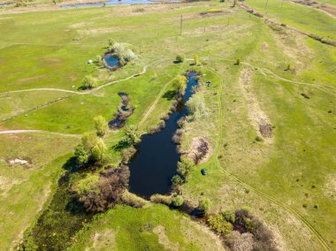 Yeşil bir çayırda nehir sızıntısı. Hava aracı görünümü.