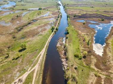 Yeşil bir çayırda nehir sızıntısı. Hava aracı görünümü.
