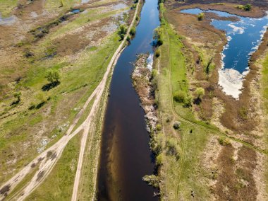 Yeşil bir çayırda nehir sızıntısı. Hava aracı görünümü.