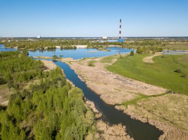Yeşil bir çayırda nehir sızıntısı. Hava aracı görünümü.