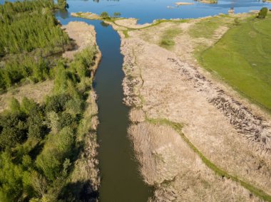 Yeşil bir çayırda nehir sızıntısı. Hava aracı görünümü.