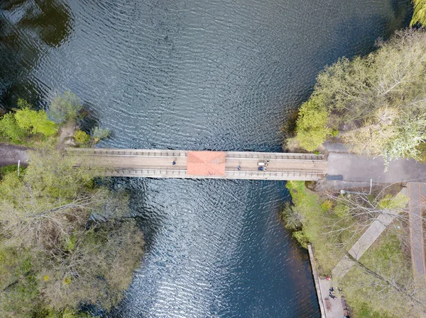 Μια Πεζογέφυρα Στο Πάρκο Απέναντι Από Ποτάμι Αεροφωτογραφία Τηλεκατευθυνόμενου — Φωτογραφία Αρχείου