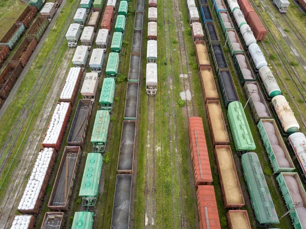 Freight trains on railway tracks. Aerial drone top view. Sunny spring day.