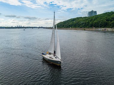 Yelkenli yat nehirde yüzüyor. Hava aracı görünümü.