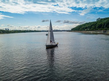 Yelkenli yat nehirde yüzüyor. Hava aracı görünümü.