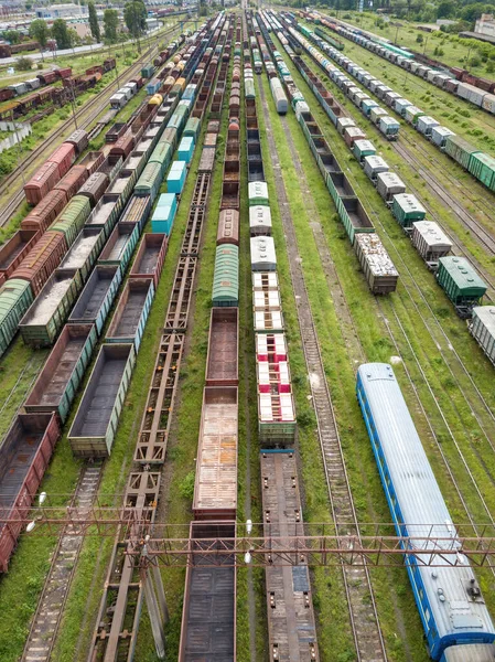 Freight trains on railway tracks. Aerial drone top view. Sunny spring day.