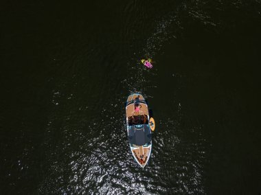 Sürat teknesi ve sörfçü yazın nehirde. Hava aracı görünümü.
