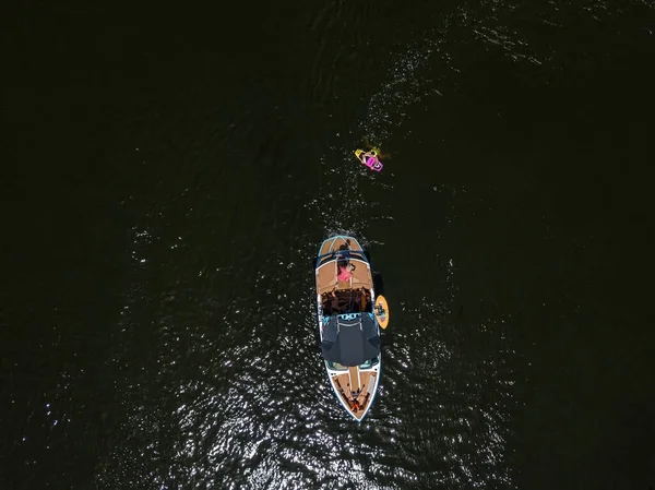 Sürat teknesi ve sörfçü yazın nehirde. Hava aracı görünümü.