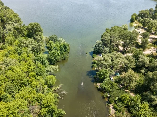 Yazın yeşil ağaçların arasında bir nehir. Hava aracı görünümü.