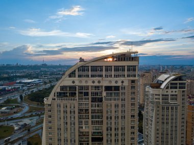Kiev 'in yerleşim bölgesindeki bulutların arasından gün batımı. Hava aracı görünümü.