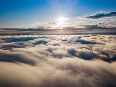 Dağlardaki sislerin üzerinden yüksek uçuş. Sabah Ukraynalı Karpatlar. Hava aracı görünümü.