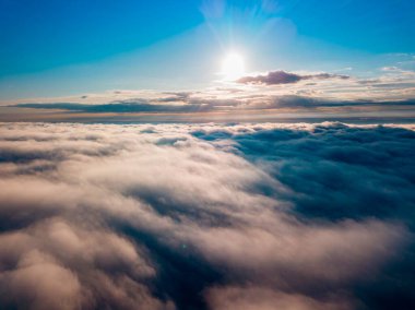 Dağlardaki sislerin üzerinden yüksek uçuş. Sabah Ukraynalı Karpatlar. Hava aracı görünümü.