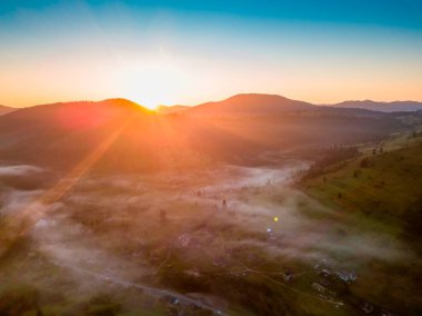 Şafakta dağ vadisinde sis var. Sabahın köründe Ukrayna Karpatları. Hava aracı görünümü.