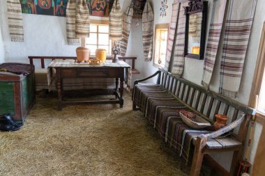 Geleneksel köy odası içi ahşap mobilyalar ve saman zeminli.