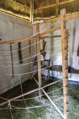 Kır evinde sazdan çatılı geleneksel ahşap dokuma tezgahı