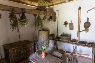 Kurutulmuş otlar ve antika aletlerle geleneksel bir mutfak.