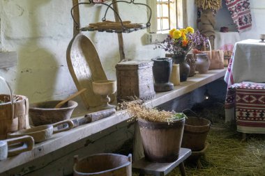 Ahşap çatal bıçaklar ve çiçeklerle döşenmiş eski bir mutfak.