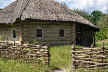 Kırsal kesimde sazdan çatılı ve tahta çitli geleneksel ahşap kulübe.