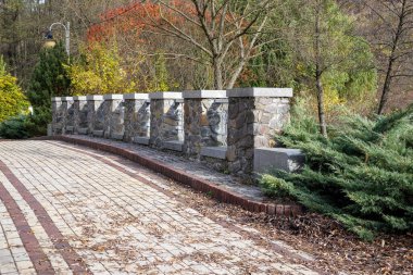 Sonbahar boyunca park yerinde sütun detaylarıyla taş köprü