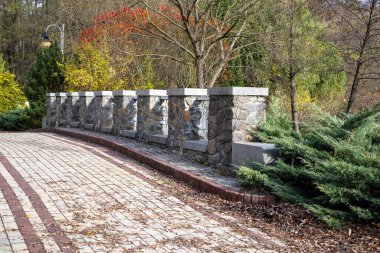 Sonbaharda park yolu boyunca sütunları olan taş çitler.