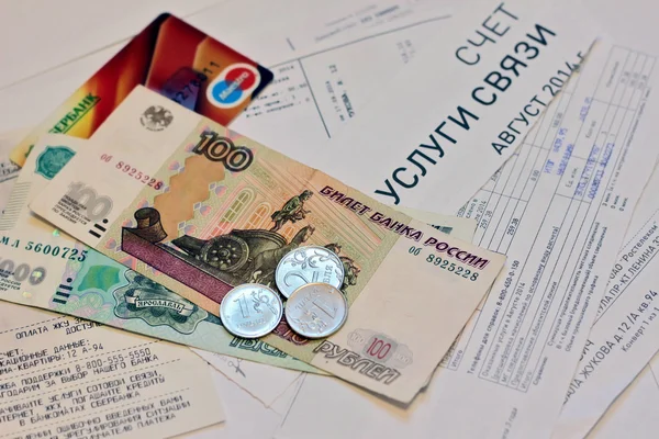 Российские деньги - примечания и монеты и платеж пластиковой карточки по квитанциям счетов за коммунальные услуги — стоковое фото