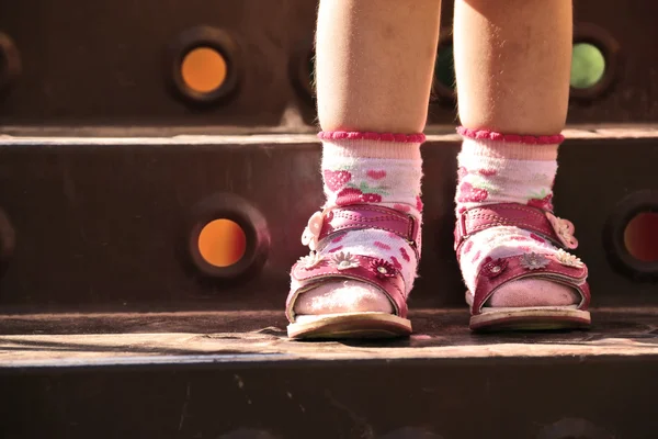 Patas de bebé en zapatos y calcetines, de pie en el escalón de las escaleras — Foto de Stock