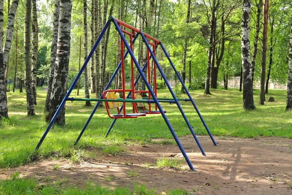 Baby swings in green birch city park — Stock Photo, Image