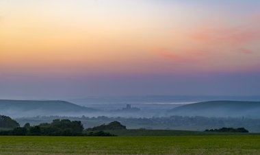 Corfe Castle günbatımı haddeleme sis ile
