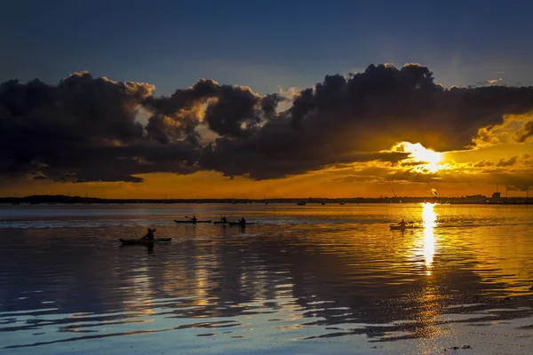 Sonnenuntergang unter Gewitterwolken an der ruhenden Küste — Stockfoto