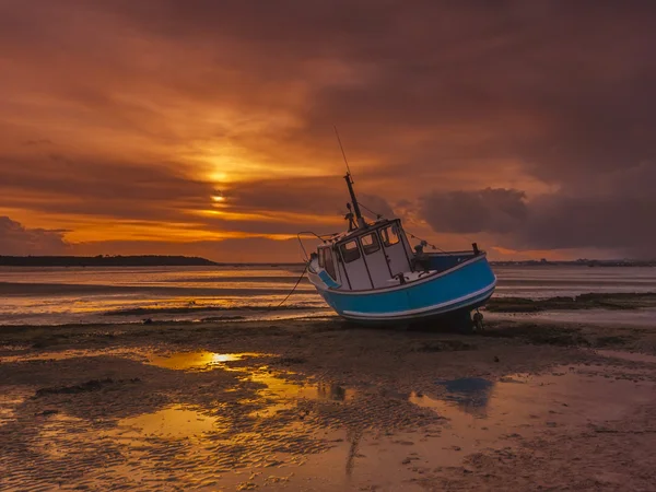 Fiskebåt jordad vid lågvatten i Poole Harbour — Stockfoto