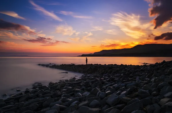 Figura solitaria se destaca mirando al mar — Foto de Stock