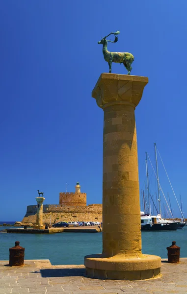 Estátuas estão de ambos os lados da entrada do porto de Mandraki — Fotografia de Stock