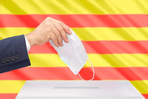Ręka Człowieka Głosującego Katalońskich Wyborach Prezydenckich Maską Medyczną Katalońską Flagą — Zdjęcie stockowe