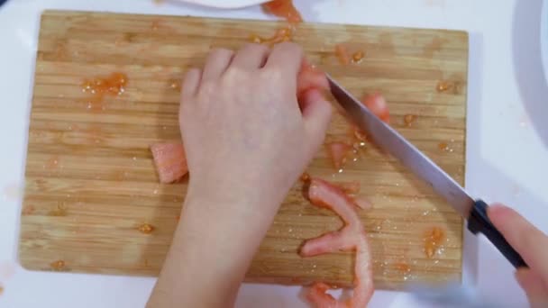 孩子们用手在木板上切西红柿的特写镜头 家庭厨房的概念 有选择的重点 — 图库视频影像