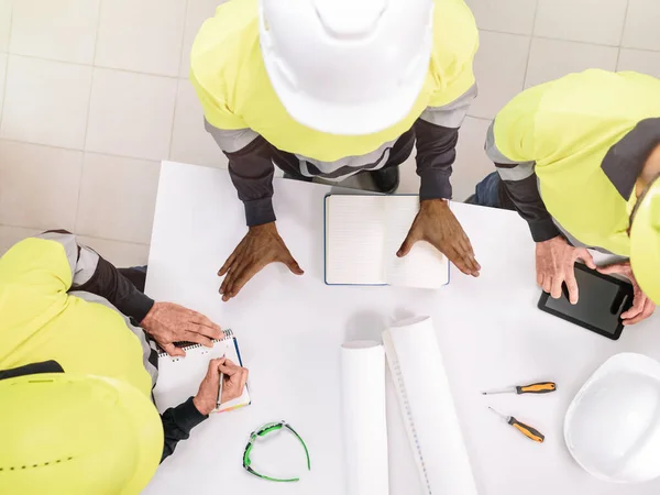 Top view of a group of a multiethnic people at work wearing helmets. Selective focus