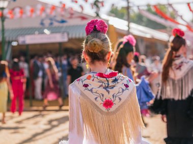 Seville, İspanya - 06 Mayıs 2025: Sevilla Fuarı 'nda flamenko elbise giyen bir kadının arka planı.