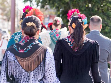 Seville, İspanya - 06 Mayıs 2025: Sevilla Fuarı 'nda renkli flamenko elbiseli kadınlar.